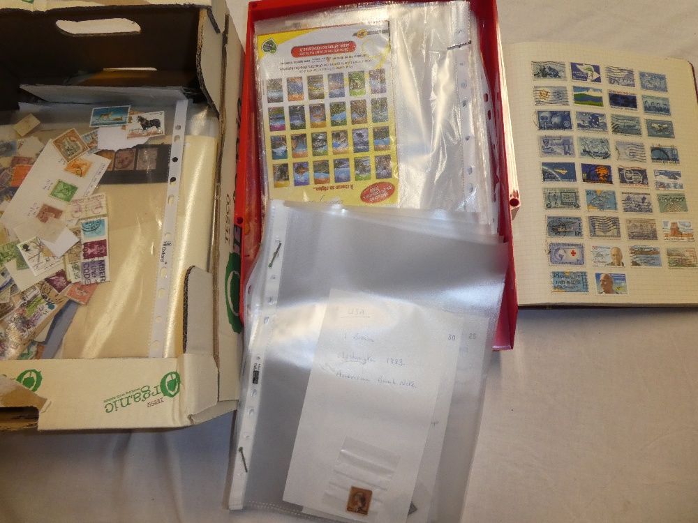 A boxed folder album containing a collection of USA stamps, various loose USA stamps,