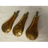 Three various brass mounted copper powder flasks including powder flask with raised game bird