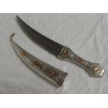 An Iraqi Jambiya dagger with 7" curved double edged blade in silver and gold mounted hilt and