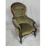 A Victorian mahogany easy chair upholstered in buttoned green draylon on scroll legs