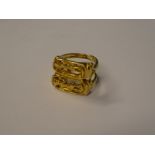 An 18ct gold dress ring with raised and pierced Egyptian figure decoration