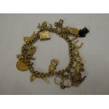 A 9ct gold charm bracelet supporting various 9ct gold and other charms