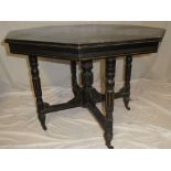 A Victorian ebonised octagonal centre table on turned supports with casters