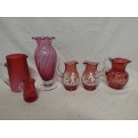 A cranberry tinted glass tapered jug with painted decoration,