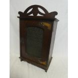 An Art Nouveau oak table cabinet with internal drawers and shelves enclosed by a single glazed door