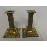 A pair of good quality brass square section table candlesticks with raised floral decoration