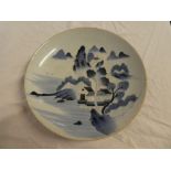 A 19th Century Japanese pottery circular shallow bowl with blue and white painted landscape