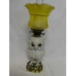 A Continental china oil lamp in the form of an owl with brass mounts and yellow tinted glass shade,