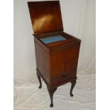 An Edwardian mahogany sewing cabinet with cupboard enclosed by two panelled door above a single