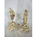 A pair of German porcelain figures of a classical male and female on floral decorated tapered bases.