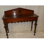 A Victorian oak rectangular side table with a drawer in one end and arched back on turned tapered