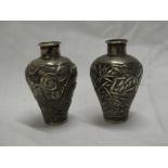 A pair of Chinese silver miniature tapered vases with raised dragon and floral decoration, signed,