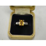 An 18ct gold dress ring set rectangular yellow topaz flanked by four small diamonds