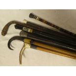 A bundle of seven various walking sticks including silver mounted walking cane, horn mounted cane,