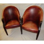 A pair of mahogany club-style easy chairs upholstered in brown leather