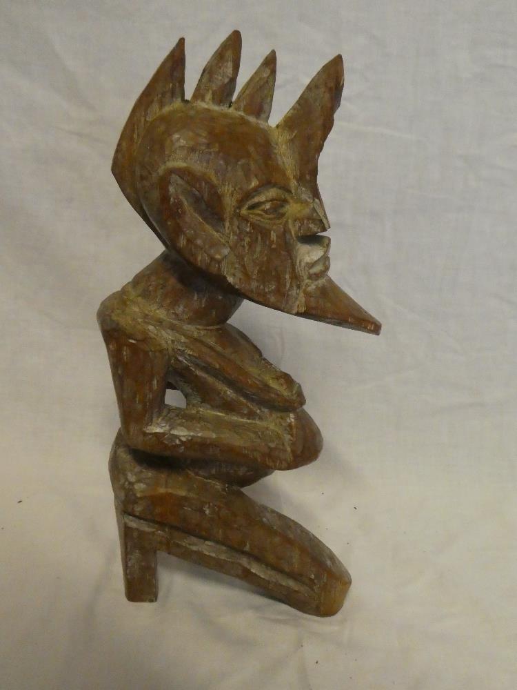 An African carved wood figure of a stylised male 12" high