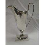 A George V silver classical-shaped pedestal cream jug with loop handle on square base,