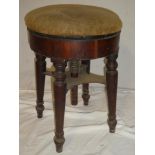 A Victorian mahogany circular revolving piano stool with upholstered seat on turned legs