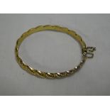 A 9ct gold oval bangle with rope-twist decoration