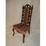 A Victorian carved walnut occasional chair with tapestry upholstered seat and back panel on