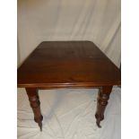 A small Victorian mahogany rectangular extending dining table with one extra centre leaf on turned