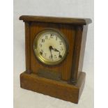 An American mantel clock with circular dial in polished oak rectangular case bearing a presentation