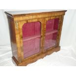 A 19th Century figured inlaid walnut display cabinet with shelves enclosed by two arched glazed