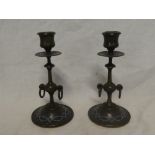 A pair of enamelled bronze tapered candlesticks with ring decoration on circular bases,