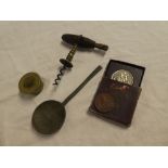 A small set of stacking brass cup weights, old pewter spoon, corkscrew with polished wood handle,