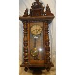 A Vienna-style wall clock with circular dial in polished mahogany glazed case with turned supports