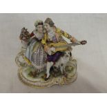A German porcelain figure of a seated male musician, female and dog on scroll-shaped base,