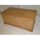 An old polished pine rectangular trunk with hinged lid on bracket feet