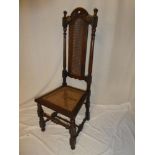 An Edwardian carved beech occasional chair with cane work seat and back panel on turned supports