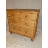An old polished pine chest of two short and two long drawers with turned handles on turned feet
