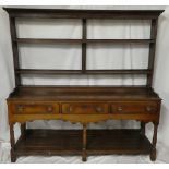 A George III oak dresser with three drawers in the frieze above open pot boards,