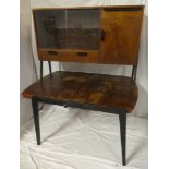 A 1960's walnut and black finished sideboard with shelves enclosed by two sliding glazed doors