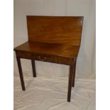 A 19th Century mahogany rectangular turnover top tea table with a small drawer in the frieze on