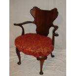 An unusual Edwardian mahogany open arm occasional chair with curved shield-shaped back and