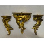 A pair of gilt painted wood scroll wall brackets and one other similar wall bracket decorated in