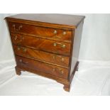 A small George III mahogany chest of four long graduated drawers with brass ring handles on bracket