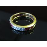 A gold diamond and ruby eternity ring. Size P/Q, 5.