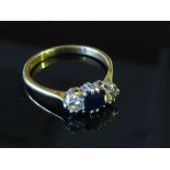 A gold ring set with single sapphire flanked by diamonds, stamped 18k, size R, 3.