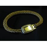 A gold woven link bracelet with a glass panel clasp,