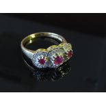 An 18ct gold cluster ring, three round cut rubies each framed by diamonds, size Q, 5.