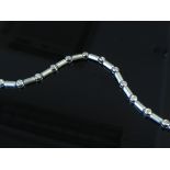 A white gold diamond bracelet each round cut diamond (19) linked by frosted white gold links