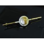 A bar brooch centrally set with brown pearl framed by diamonds, unmarked, 6.