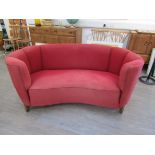 A Danish 1940's curved two seater sofa, original red wool upholstery, tapering square oak legs,