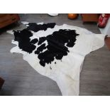 A cow hide rug in black and white.