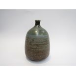 PETER LANE (b.1932): An early stoneware bottle vase with blue/green glaze and incised line detail.