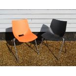 A pair of stacking chairs in black and orange designed by Angelo Pinaffo for Shell,